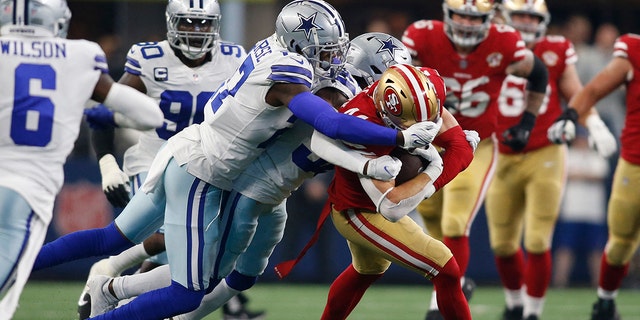 Jan 16, 2022; Arlington, Texas, USA; San Francisco 49ers fullback Kyle Juszczyk (44) is tackled by Dallas Cowboys safety Jayron Kearse (27) in the first quarter in a NFC Wild Card playoff football game at AT&amp;T Stadium.