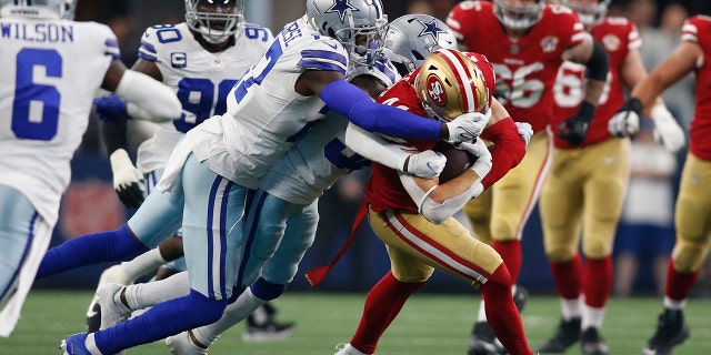 Jan 16, 2022; Arlington, Texas, USA; San Francisco 49ers fullback Kyle Juszczyk (44) is tackled by Dallas Cowboys safety Jayron Kearse (27) in the first quarter in a NFC Wild Card playoff football game at AT&T Stadium.