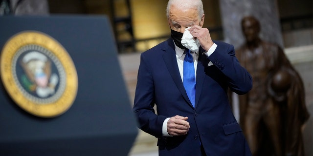 President Biden wipes his eyes as Vice President Kamala Harris speaks at the U.S. Capitol to mark one year since Jan. 6.