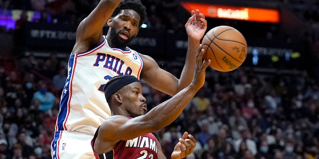 Miami Heat forward Jimmy Butler (22) passes the ball as Philadelphia 76ers center Joel Embiid defends during the second half of an NBA basketball game, Sabato, Jan. 15, 2022, a Miami.
