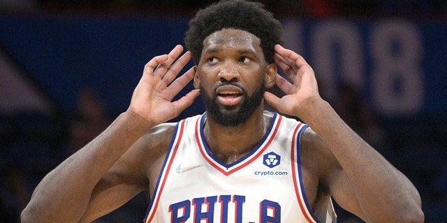 Philadelphia 76ers center Joel Embiid (21) interacts with fans after a score during the second half of an NBA basketball game against the Orlando Magic, 星期三, 一月. 5, 2022, in Orlando, 弗拉.