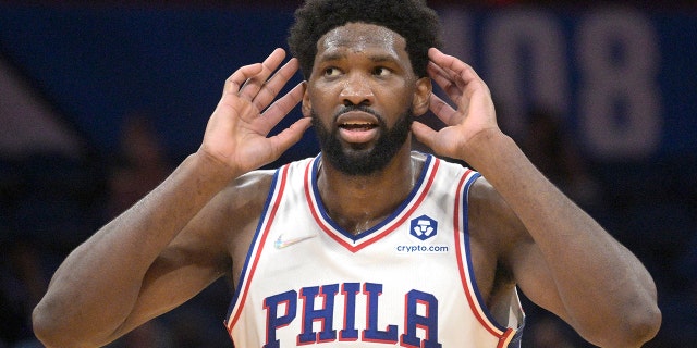 Philadelphia 76ers center Joel Embiid (21) interacts with fans after a score during the second half of an NBA basketball game against the Orlando Magic, 星期三, 一月. 5, 2022, in Orlando, 弗拉.