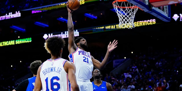 Philadelphia 76ers' Joel Embiid (21) goes up for a dunk during the first half of an NBA basketball game against the Orlando Magic, 水曜日, 1月. 19, 2022, フィラデルフィアで.