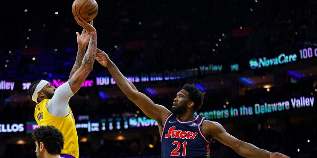 Los Angeles Lakers' Anthony Davis, 왼쪽, shoots the ball with Philadelphia 76ers' Joel Embiid, 권리, defending during the first half of an NBA basketball game, 목요일, 1 월. 27, 2022, 필라델피아.