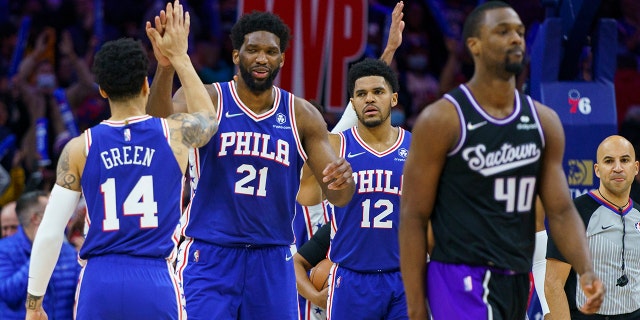 Philadelphia 76ers' Joel Embiid, center left, celebrates the win with Danny Green, left, and Tobias Harris, center right, after the missed shot by Sacramento Kings' Harrison Barnes, right, during the second half of an NBA basketball game, Saturday, Jan. 29, 2022, in Philadelphia.