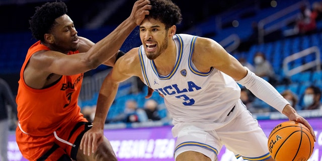 UCLA guard Johnny Juzang, destra, drives past Oregon State guard Dexter Akanno during the second half of an NCAA college basketball game Saturday, Jan. 15, 2022, a Los Angeles. UCLA won 81-65.