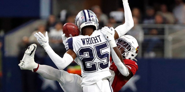 Dallas Cowboys cornerback Nahshon Wright (25) hits Arizona Cardinals running back Jonathan Ward (29) as he reaches to catch a pass during the first half of an NFL football game Sunday, Jan. 2, 2022, in Arlington, Texas. Wright was called for pass interference.