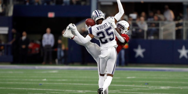 Dallas Cowboys cornerback Nahshon Wright (25) hits Arizona Cardinals running back Jonathan Ward (29) as he reaches to catch a pass during the first half of an NFL football game Sunday, Jan. 2, 2022, in Arlington, Texas. Wright was called for pass interference.