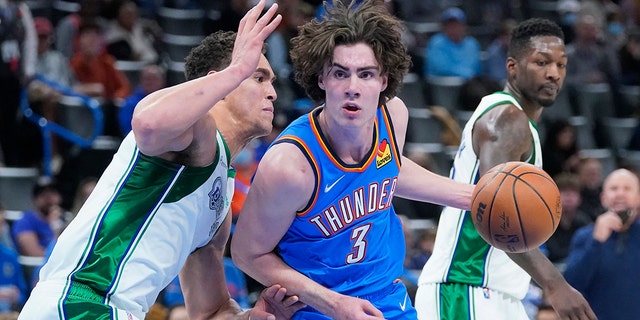 Oklahoma City Thunder guard Josh Giddey (3) drives past Dallas Mavericks center Dwight Powell, left, in the second half of an NBA basketball game Sunday, Jan. 2, 2022, in Oklahoma City. 