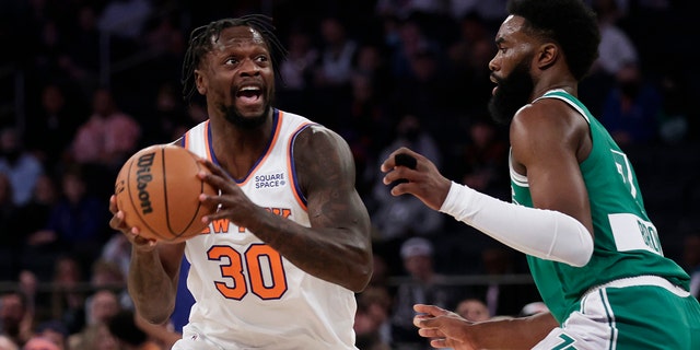 New York Knicks forward Julius Randle (30) looks to pass the ball around Boston Celtics guard Jaylen Brown during the first half of a game Thursday, Jan. 6, 2022, in New York.