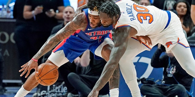 Detroit Pistons forward Saddiq Bey (41) and New York Knicks forward Julius Randle (30) reach for a loose ball during the second half of an NBA basketball game, Woensdag, Des. 29, 2021, in Detroit.