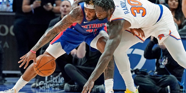 Detroit Pistons forward Saddiq Bey (41) and New York Knicks forward Julius Randle (30) reach for a loose ball during the second half of an NBA basketball game, Wednesday, Dec. 29, 2021, in Detroit.
