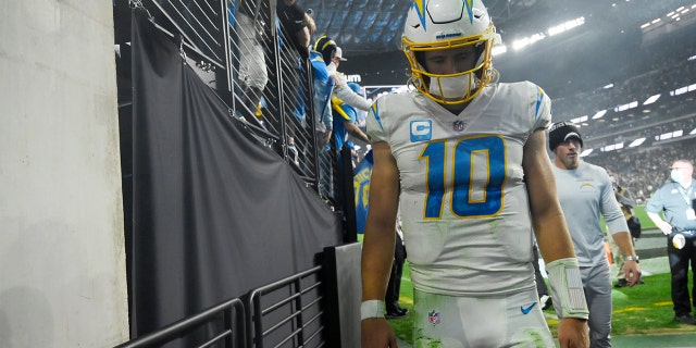 Los Angeles Chargers quarterback Justin Herbert (10) walks off the field after the Los Angeles Chargers lost to the Las Vegas Raiders in overtime of an NFL football game, Sunday, Jan. 9, 2022, in Las Vegas.