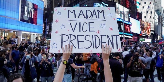A person holds a sign as others celebrate after media announced that Democratic U.S. presidential nominee Joe Biden has won the 2020 U.S. presidential election, on Times Square in New York City, U.S., November 7, 2020. REUTERS/Carlo Allegri