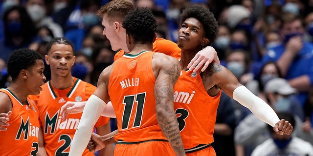 Miami guards Jordan Miller (11) and Kameron McGusty celebrate with Charlie Moore (3), Isaiah Wong (2) and forward Sam Waardenburg during the second half of the team's NCAA college basketball game against Duke in Durham, N.C., Saturday, Jan. 8, 2022. 