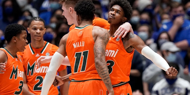 Miami guards Jordan Miller (11) and Kameron McGusty celebrate with Charlie Moore (3), Isaiah Wong (2) and forward Sam Waardenburg during the second half of the team's NCAA college basketball game against Duke in Durham, N.C., Saturday, Jan. 8, 2022. 