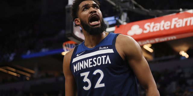 Minnesota Timberwolves center Karl-Anthony Towns (32) reacts after scoring a basket during the first half of an NBA basketball game against the Golden State Warriors, Sunday Jan. 16, 2022, en Minneapolis.