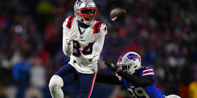 January 15, 2022; Orchard Park, New York, USA; New England Patriots wide receiver Kendrick Bourne (84) strikes a blow against Buffalo Bill's cornerback Levi Wallace (39) in the first quarter of the AFC Wild Card playoffs at Highmark Stadium.