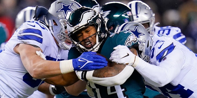 Philadelphia Eagles running back Kenneth Gainwell (14) runs with the ball as Dallas Cowboys outside linebacker Leighton Vander Esch, left, and defensive end Randy Gregory, right, try to stop him during the first half of an NFL football game, Saturday, Jan. 8, 2022, in Philadelphia.