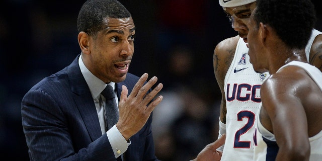 文件 - Connecticut head coach Kevin Ollie, 剩下, talks with Connecticut's Terry Larrier and Christian Vital, 对, during an NCAA college basketball game, 星期三, 二月. 7, 2018, in Storrs, 康恩.