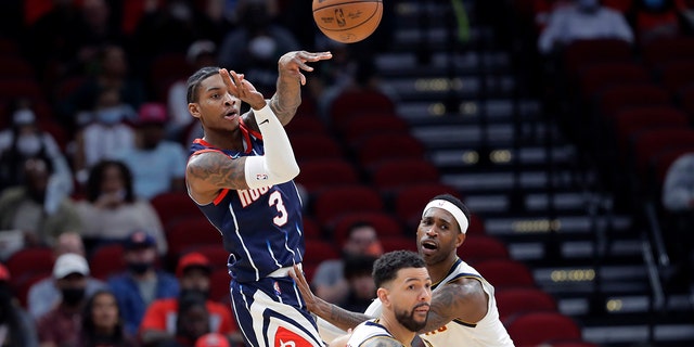 Houston Rockets guard Kevin Porter Jr. (3) passes the ball over Denver Nuggets guard Austin Rivers, middle and forward Will Barton, right, during the first half of an NBA basketball game Saturday, Jan. 1, 2022, in Houston.