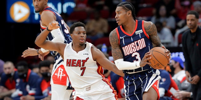 Houston Rockets guard Kevin Porter Jr. (3) looks to pass the ball as Miami Heat guard Kyle Lowry (7) defends during the first half of an NBA basketball game Friday, Dec. 31, 2021, in Houston.