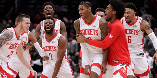 Houston Rockets Kevin Porter Jr., front second from right in front, celebrates with his teammates after making the game-winning 3-point shot in the team's NBA basketball game against the Washington Wizards, miércoles, ene. 5, 2022, en Washington.