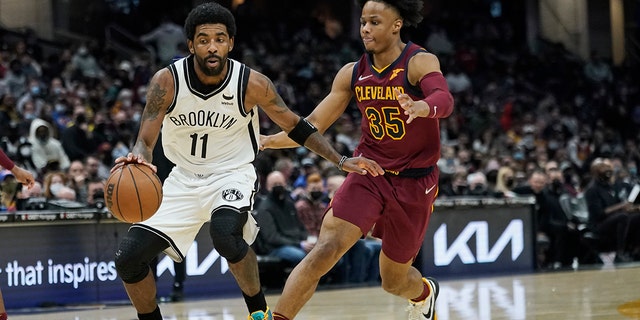 Brooklyn Nets' Kyrie Irving (11) drives against Cleveland Cavaliers' Isaac Okoro (35) in the second half of an NBA basketball game, Maandag, Jan.. 17, 2022, in Cleveland.