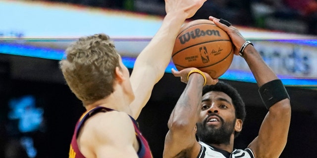 Brooklyn Nets' Kyrie Irving (11) shoots over Cleveland Cavaliers' Lauri Markkanen, links, in the second half of an NBA basketball game, Maandag, Jan.. 17, 2022, in Cleveland.