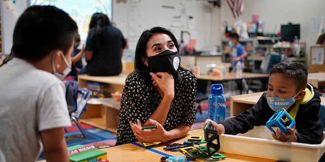 Teacher Juliana Urtubey, center, works with Brian Avilas, left, and Jesus Calderon Lopez, right, in a class at Kermit R. Booker Sr. Elementary School Wednesday, May 5, 2021, in Las Vegas. 