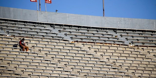 9 月 9 日，在军团球场举行的 NCAA 大学橄榄球比赛之前，一名孤独的球迷坐在看台上等待 UAB 和中阿肯色州之间的开球。  2020 年 3 月 3 日，阿拉巴马州伯明翰。