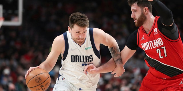 Dallas Mavericks guard Luka Doncic drives past Portland Trail Blazers center Jusuf Nurkic during the first half of an NBA basketball game in Portland, Ore., Wednesday, Jan. 26, 2022.