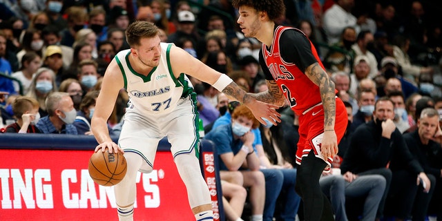 Dallas Mavericks guard Luka Doncic (77) is guarded by Chicago Bulls guard Lonzo Ball (2) in the first half of an NBA basketball game in Dallas, 星期日, 一月. 9, 2022.