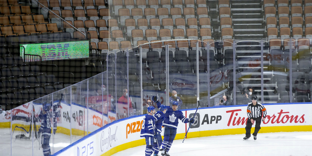 Toronto Maple Leafs' Ilya Mikheyev (65) celebrates with teammates after scoring his team's fifth goal against Ottawa Senators in front of empty seats during third period of an NHL hockey game in Toronto on Saturday.