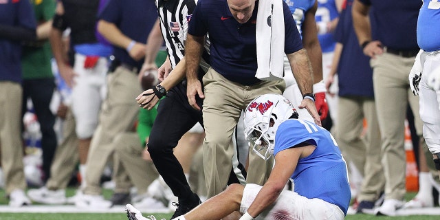 Durante el Allstate Sugar Bowl en el Caesars Superdome en Nueva Orleans, Louisiana, el 1 de enero de 2022, Matt Coral de los Mississippi Rebels es observado por un entrenador herido contra los Baylor Bears.