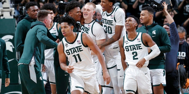 Michigan State players, including A.J. Hoggard (11), Marcus Bingham Jr. (30), Tyson Walker (2) and Joey Hauser, center, celebrate after defeating Minnesota in an NCAA college basketball game, Wednesday, Jan. 12, 2022, in East Lansing, Mich. Michigan State won 71-69.