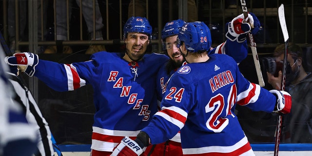 New York Rangers center Mika Zibanejad (93) is congratulated by teammates Chris Kreider (20) and Kaapo Kakko (24) after scoring his third goal against the Tampa Bay Lightning, during the second period of an NHL hockey game, 星期日, 一月 2, 2022, at Madison Square Garden in New York.
