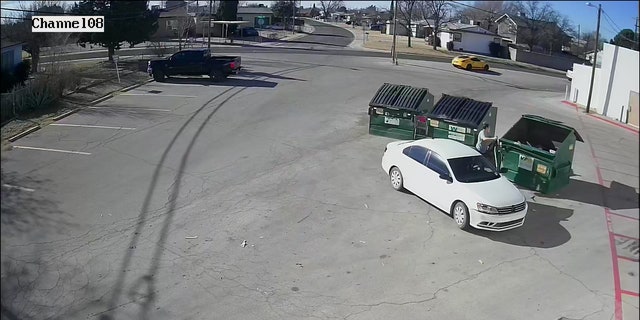 The video shows a woman pulling up in a white car around 2 午後. MT Friday, unceremoniously tossing a black bag from the backseat into the dumpster and driving off.