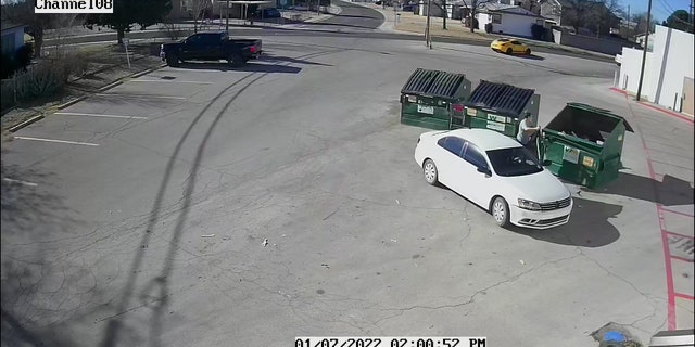 The video shows a woman pulling up in a white car around 2 p.m. MT Friday, unceremoniously tossing a black bag from the backseat into the dumpster and driving off.