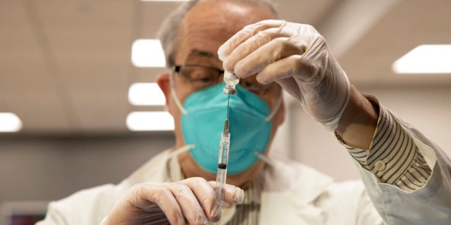 ARQUIVO - O farmacêutico da CVS Gerard Diebner prepara a vacina COVID-19 para os residentes do lar de idosos no Harlem Center for Nursing and Rehabilitation, um lar de idosos, em 15 de janeiro de 2021, no bairro do Harlem, em Nova York.