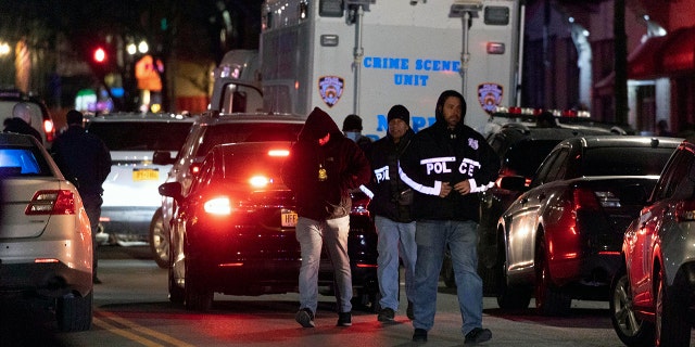 NYPD officers investigate the scene of a shooting in Harlem on Friday, Jan.. 21, 2022, In New York. A New York Police Department officer was killed and another gravely injured Friday night after responding to a domestic disturbance call, according to a law enforcement official.