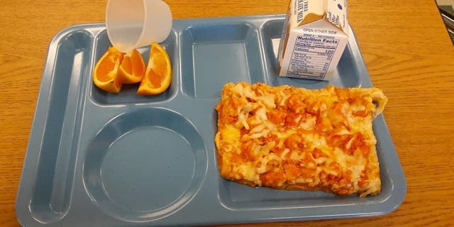 Seen in this image provided by father Chris Vangellow of Hopkinton, New York, is a plate containing milk, pizza and three orange slices — a free lunch one of his children has been served at school under USDA guidelines.