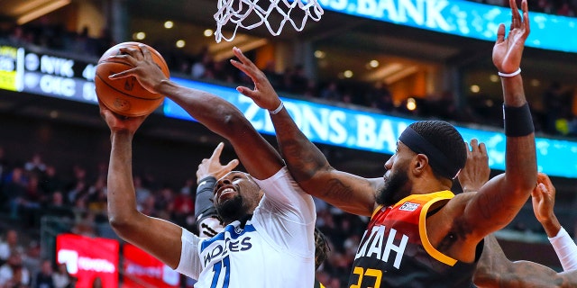 Minnesota Timberwolves center Naz Reid (11) goes up for a shot while Utah Jazz forward Royce O'Neale (23) defends during the first half of an NBA basketball game Friday, 12 월. 31, 2021, in Salt Lake City.