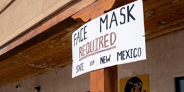 Face masks required signs are posted outside the Indian Village Gift Shop in Continental Divide, N.M.
