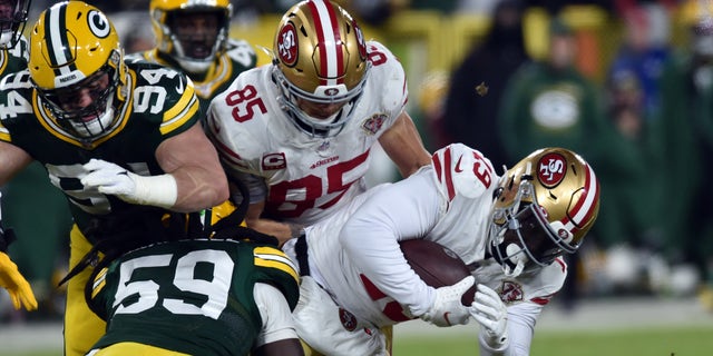 Jan. 22, 2022; Groenbaai, Wisconsin, VSA; San Francisco 49ers wide receiver Deebo Samuel (19) is tackled by Green Bay Packers inside linebacker De'Vondre Campbell (59) during the second quarter during a NFC Divisional playoff football game at Lambeau Field. Verpligte krediet: Jeffrey Becker-USA TODAY Sports