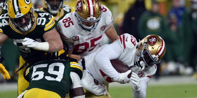 Jan 22, 2022; Green Bay, Wisconsin, Stati Uniti d'America; San Francisco 49ers wide receiver Deebo Samuel (19) is tackled by Green Bay Packers inside linebacker De'Vondre Campbell (59) during the second quarter during a NFC Divisional playoff football game at Lambeau Field. Mandatory Credit: Jeffrey Becker-USA TODAY Sports