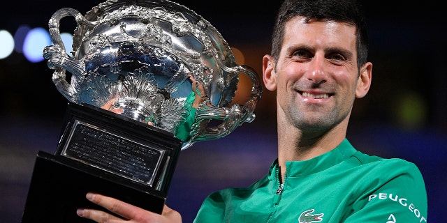 Serbia's Novak Djokovic holds the Norman Brookes Challenge Cup after defeating Russia's Daniil Medvedev in the men's singles final at the Australian Open tennis championship in Melbourne, Australia, Sunday, Feb. 21, 2021.