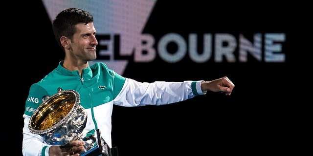 FILE - Serbia's Novak Djokovic holds the Norman Brookes Challenge Cup after defeating Russia's Daniil Medvedev in the men's singles final at the Australian Open tennis championship in Melbourne, Australia, Sunday, Feb. 21, 2021.