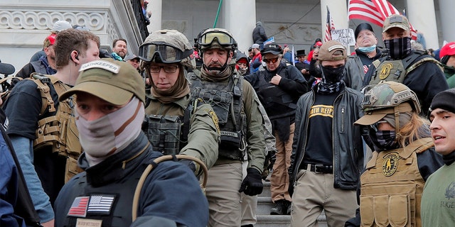 FILE PHOTO: Jessica Marie Watkins, second from left, and Donovan Ray Crowl, center, both from Ohio, march down the east front steps of the U.S. Capitol with the Oath Keepers militia group among supporters of President Trump in Washington, Jan. 6, 2021.  