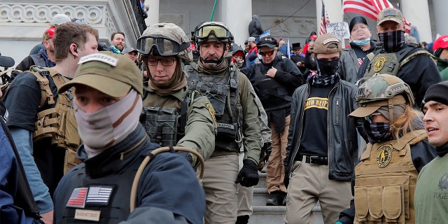 FILE PHOTO: Jessica Marie Watkins, second from left, and Donovan Ray Crowl, center, both from Ohio, march down the east front steps of the U.S. Capitol with the Oath Keepers militia group among supporters of President Trump in Washington, Jan. 6, 2021.  